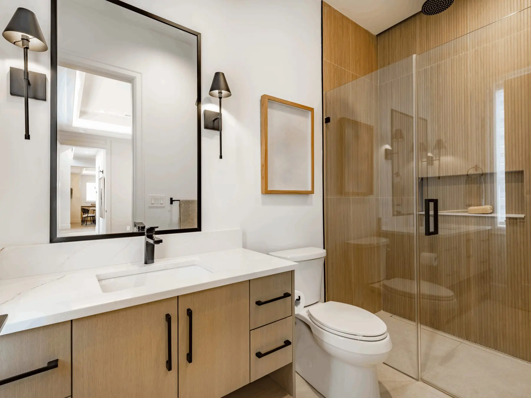 Modern bathroom with wooden cabinets and glass shower enclosure.