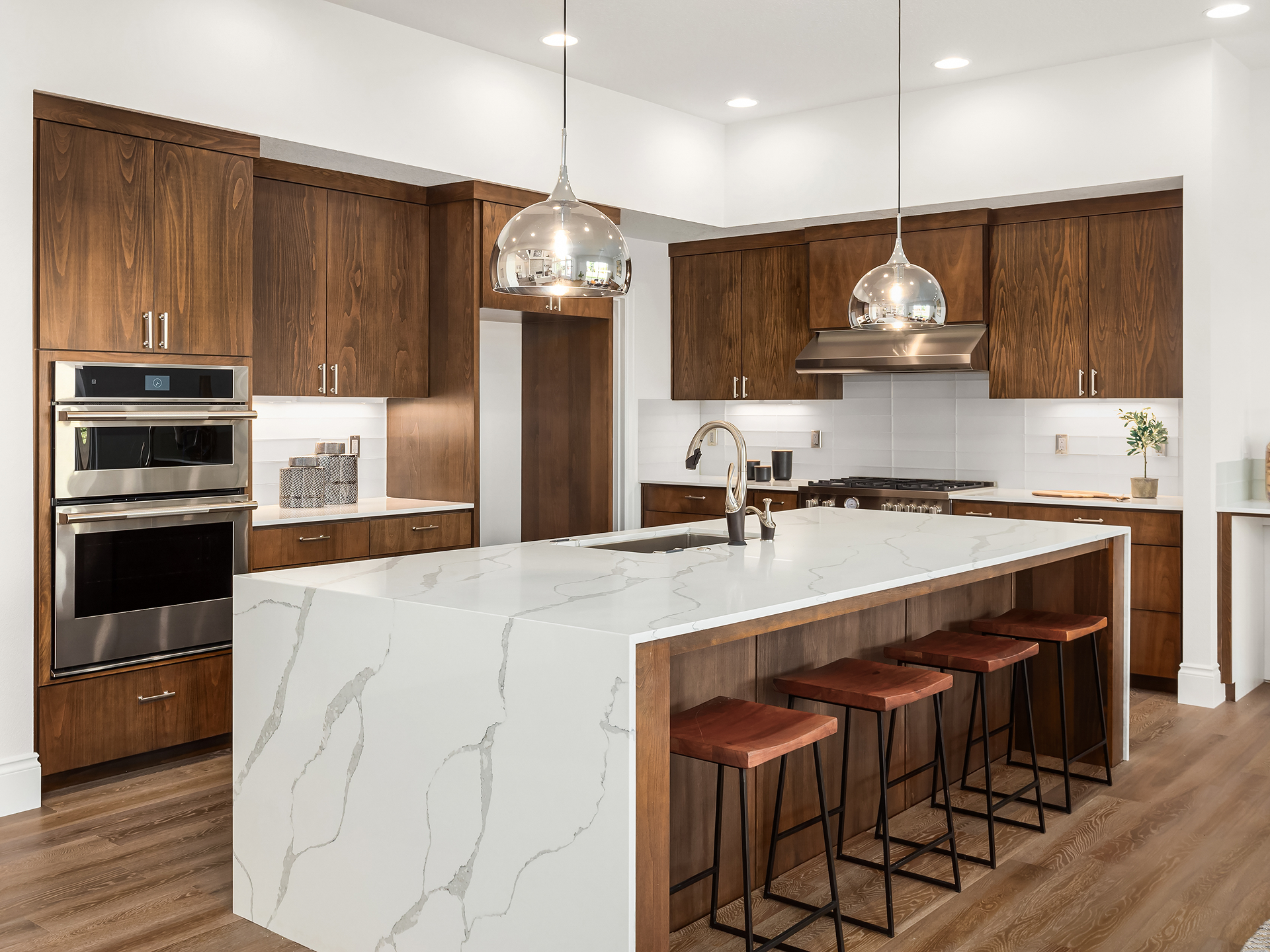 Modern kitchen with marble island and wooden cabinetry.
