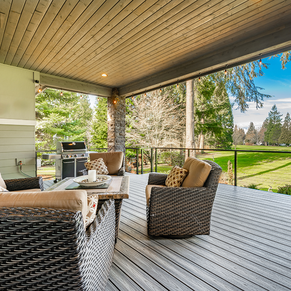 Covered deck with wicker furniture overlooking yard