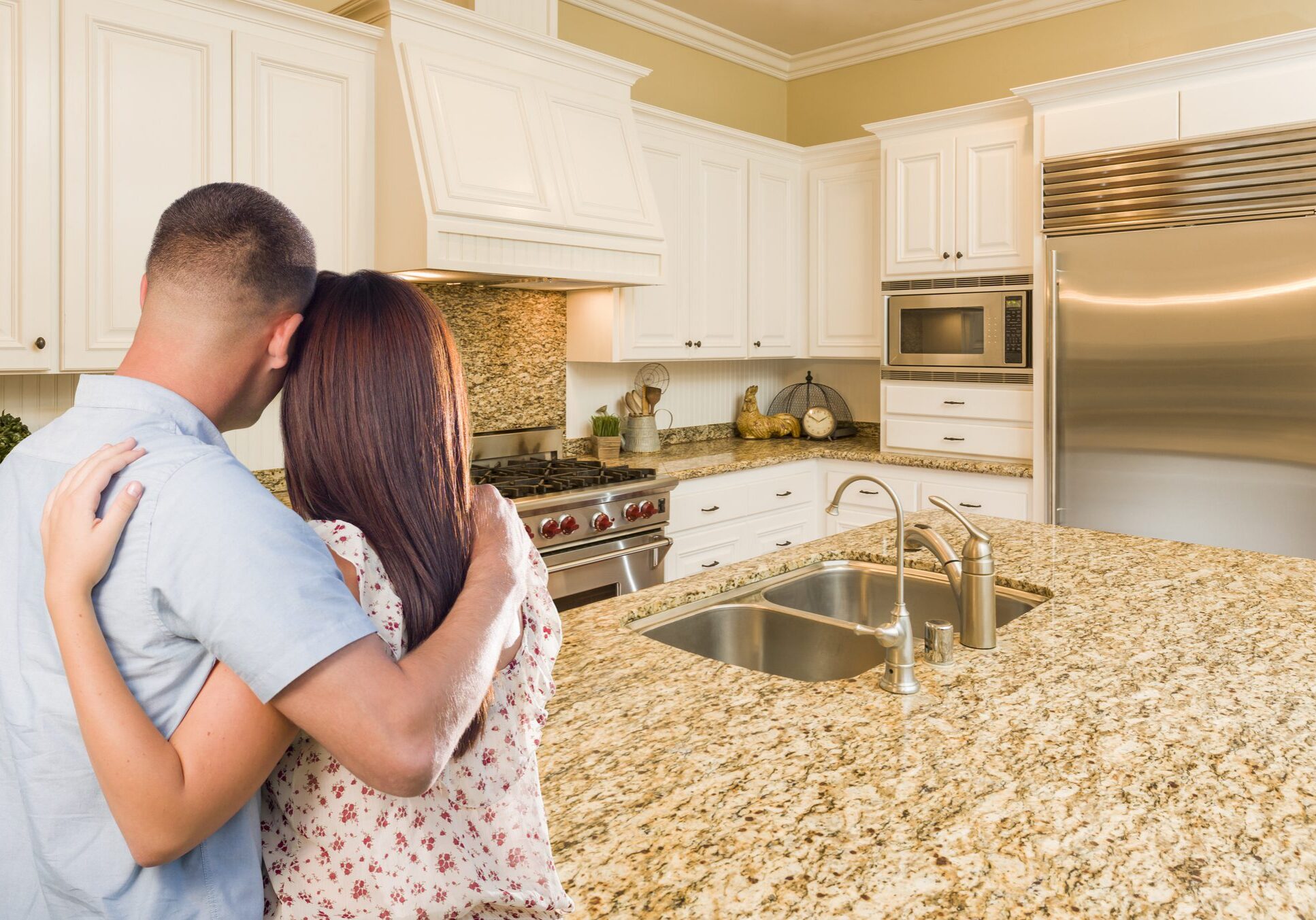 Couple embracing in kitchen with granite countertop